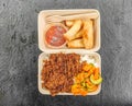 Beef rendang curry with rice and pickles in a take out carton Royalty Free Stock Photo