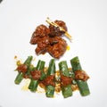 Beef rendang on white plate with rolled cassava leaves Royalty Free Stock Photo