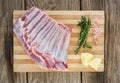 Beef ribs, rosemary herb, salt and lemon on wooden board