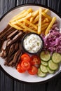 Beef shawarma with vegetables and sauce serving on a plate close-up. Vertical top view Royalty Free Stock Photo