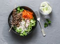 Beef skewers, rice vermicelli, pickled vegetables salad carrots, cucumbers, radishes, greens and lemon thyme lemonade on grey back