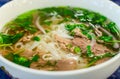 Beef soup pho bo soup, Vietnamese cuisine, first course with noodles and vegetables soup in a white bowl, closeup. Street food Royalty Free Stock Photo