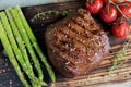 Beef steak with asparagus tomatoes spice on a wooden surface