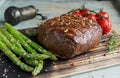 Beef steak with asparagus tomatoes spice on a wooden surface