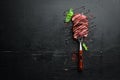 Beef steak on a fork. On a wooden background. Royalty Free Stock Photo