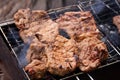 Beef steak on grill. Meat on coals with smoke Royalty Free Stock Photo