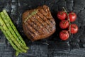 Beef steak grilled with asparagus tomatoes spice on charcoal Royalty Free Stock Photo