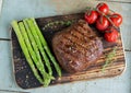 Beef steak grilled with asparagus tomatoes spice on a wooden surface