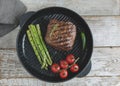 Beef steak grilled in the frying pan with asparagus tomatoes spice