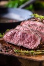 Beef steak. Juicy medium Rib Eye steak slices on wooden board with fork and knife herbs spices and salt Royalty Free Stock Photo