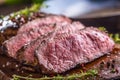 Beef steak. Juicy medium Rib Eye steak slices on wooden board with fork and knife herbs spices and salt Royalty Free Stock Photo