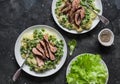 Beef steak with mashed potatoes and creamy green peas sauce on dark background, top view