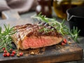 Beef Steak medium rare on black plate, surfed with tableware on black stone table with ample copy space. Dark background. Royalty Free Stock Photo