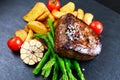 Beef steak Mignon cooked with Asparagus, potatoes, garlic and tomatoes. Royalty Free Stock Photo