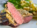 Beef steak with mustard herb crust and romaine lettuce hearts wi Royalty Free Stock Photo