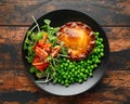 Beef steak pies with rich onion gravy served with sweet peas and salad Royalty Free Stock Photo