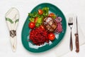 Beef steak with a side dish of carrots, beets and tomatoes on a green plate Royalty Free Stock Photo