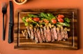 Beef steak on a wooden background. Sliced grilled meat barbecue steak Strip loin with knife and fork carving set on wooden Cutting Royalty Free Stock Photo