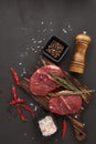 Beef steaks on cutting board and spices on black slate background. Top view. Steak menu Royalty Free Stock Photo