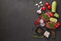 Beef steaks on cutting board, vegetables  and spices on black slate background. Top view. Steak menu Royalty Free Stock Photo