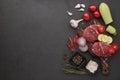 Beef steaks on cutting board, vegetables  and spices on black slate background. Top view. Steak menu Royalty Free Stock Photo