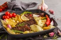 Beef steaks grilled with baked potatoes and vegetables in a pan Royalty Free Stock Photo