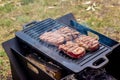 Beef steaks grilling on a cast iron plate on a camp fire. Campfire cooking Royalty Free Stock Photo