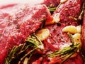 Beef steaks marinated for barbeque with olive oil, garlic, rosemary and herbs. Close up, Selective focus Royalty Free Stock Photo