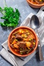 Beef stew with potato, green beans, carrot, peas and corn, in ceramic bowl, vertical, top view Royalty Free Stock Photo