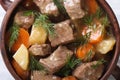 Beef stew with vegetables and herbs in a pot macro top view. Royalty Free Stock Photo