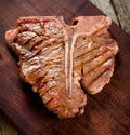 Beef T-bone steaks on dark old wooden board