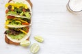 Beef tacos with salad, tomato and beer.