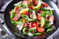 Beef tagliata salad on a black plate, close-up