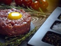 Beef tartar with an egg on a stone plate. Royalty Free Stock Photo