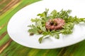 Beef tartare with capers on a green wooden table