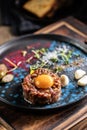 Beef tartare with egg yolk on a plate with garlic and toasted bread Royalty Free Stock Photo