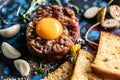 Beef tartare with egg yolk on a plate with garlic and toasted bread Royalty Free Stock Photo