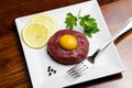 Beef tartare with egg yolk on a white plate