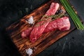 Beef tenderloin on a wood Board with salt and thyme top view