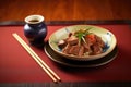 beef teriyaki with chopsticks and sake cup on bamboo mat Royalty Free Stock Photo