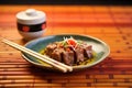 beef teriyaki with chopsticks and sake cup on bamboo mat Royalty Free Stock Photo