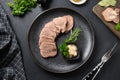 Sliced beef tongue with horseradish sauceon black. View from above