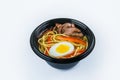 Udon Soup with egg, udon noodles and beef fillet served in plastic delivery bowl isolated on gray background Royalty Free Stock Photo