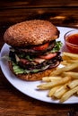 Beefburger with fried sweet potatoes served on a white plate Royalty Free Stock Photo