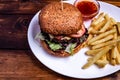 Beefburger with fried sweet potatoes served on white plate