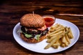 Beefburger with fried sweet potatoes served on a white plate Royalty Free Stock Photo