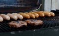 Beefburgers and sausages cooking on an open grill Royalty Free Stock Photo