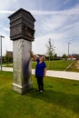 A mature woman examines the Beehive Memorial to the Latvian prisoners of war held at the nearby Zedelgem Camp