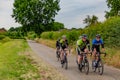 Beek, South Limburg / Netherlands. June 14th, 2020. Small group of cyclists pedaling on a rural road among trees and vegetation