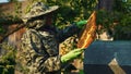 Beekeeper checking beehive in protective suit. Medium shot